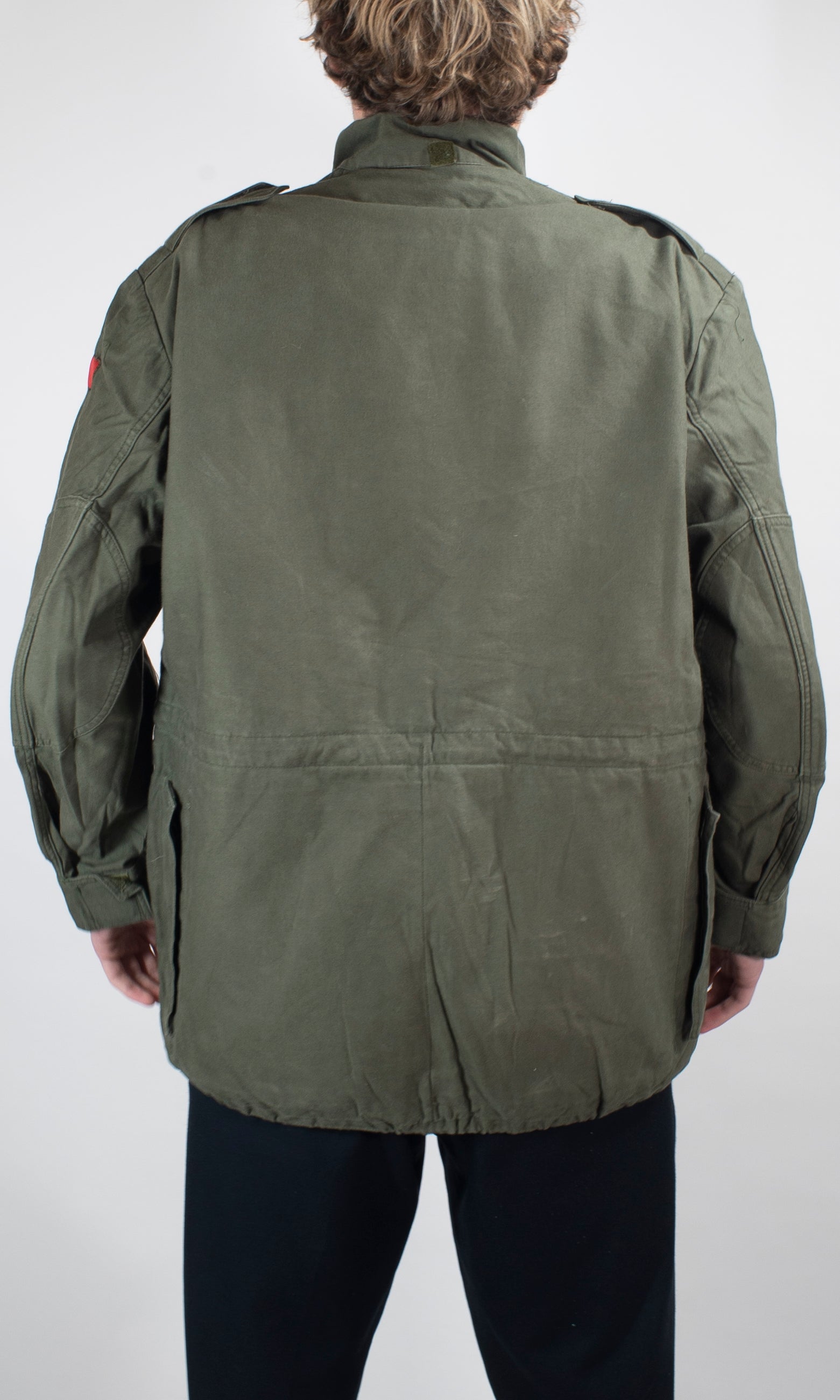 Back view of the vintage Belgian military field jacket featuring a hidden poachers pocket and durable heavy-duty olive cotton canvas material.