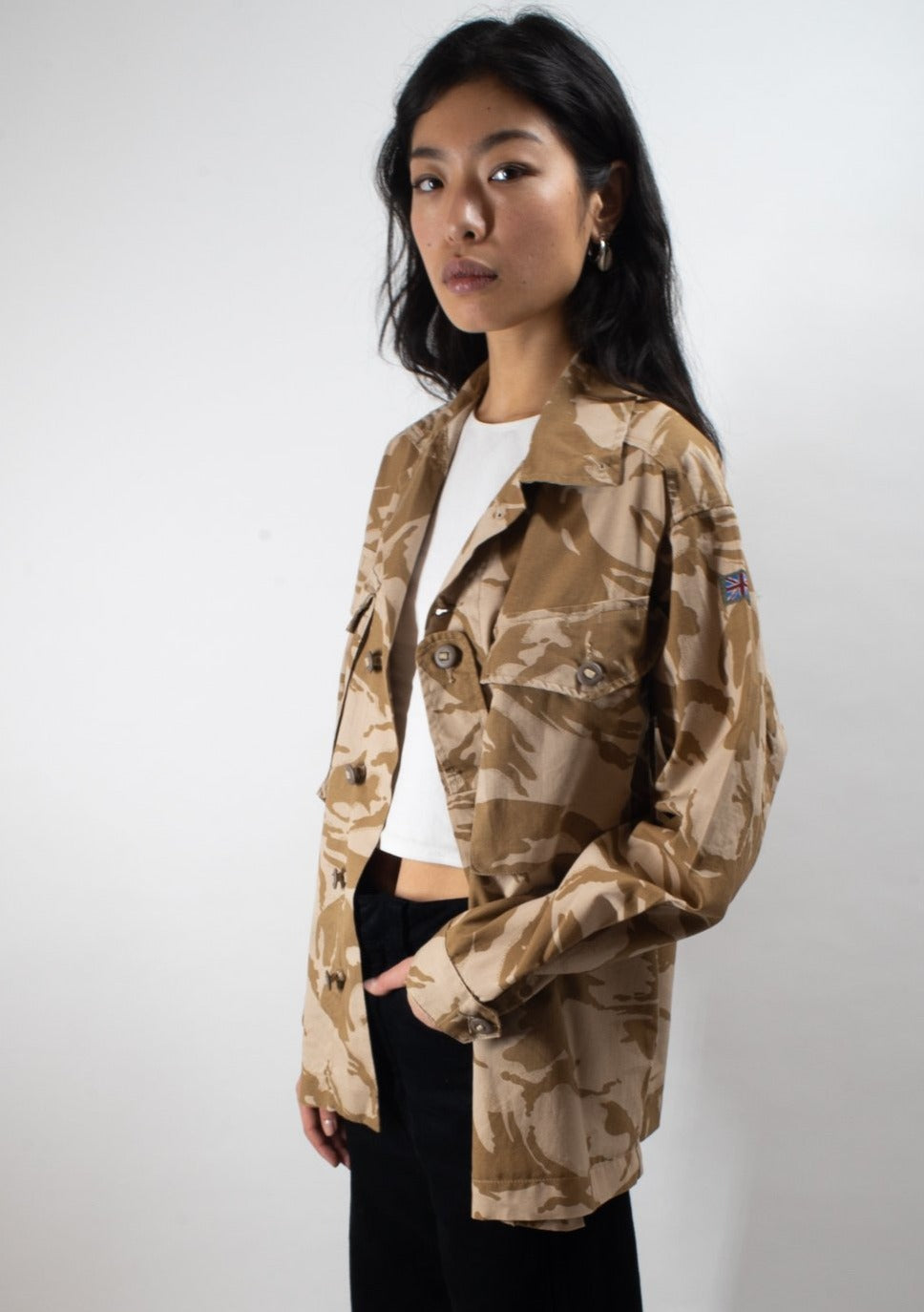 Side profile of the British combat shirt worn by a model, showing the fit and sleeve-mounted Union Jack patch.