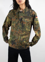 Front close-up of women's Bundeswehr Flecktarn field shirt with tactical chest pockets, hook-and-loop utility space, and durable cotton-polyester blend.