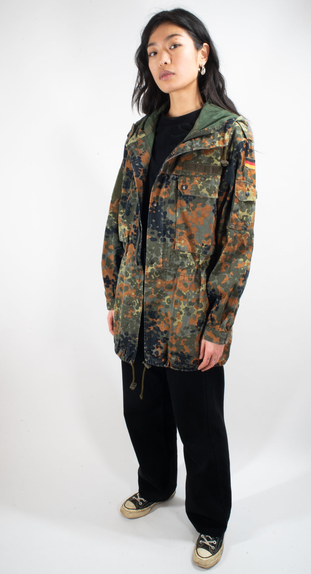 Model wearing an authentic German military surplus Flecktarn parka with a classic rugged field aesthetic.