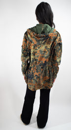 Back view of the Flecktarn field jacket on a model, showing the adjustable hem and durable construction.