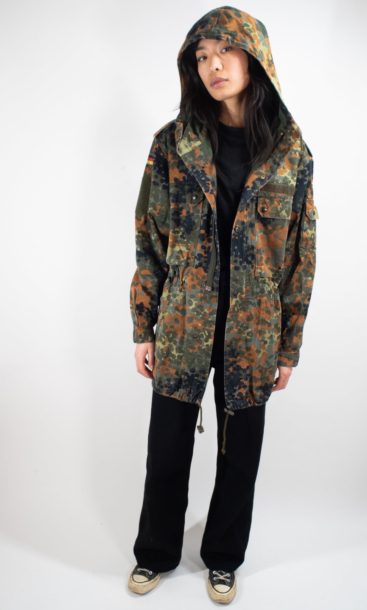 Full-length shot of the Bundeswehr Feldparka with hood up, displaying the functional design and camo pattern.