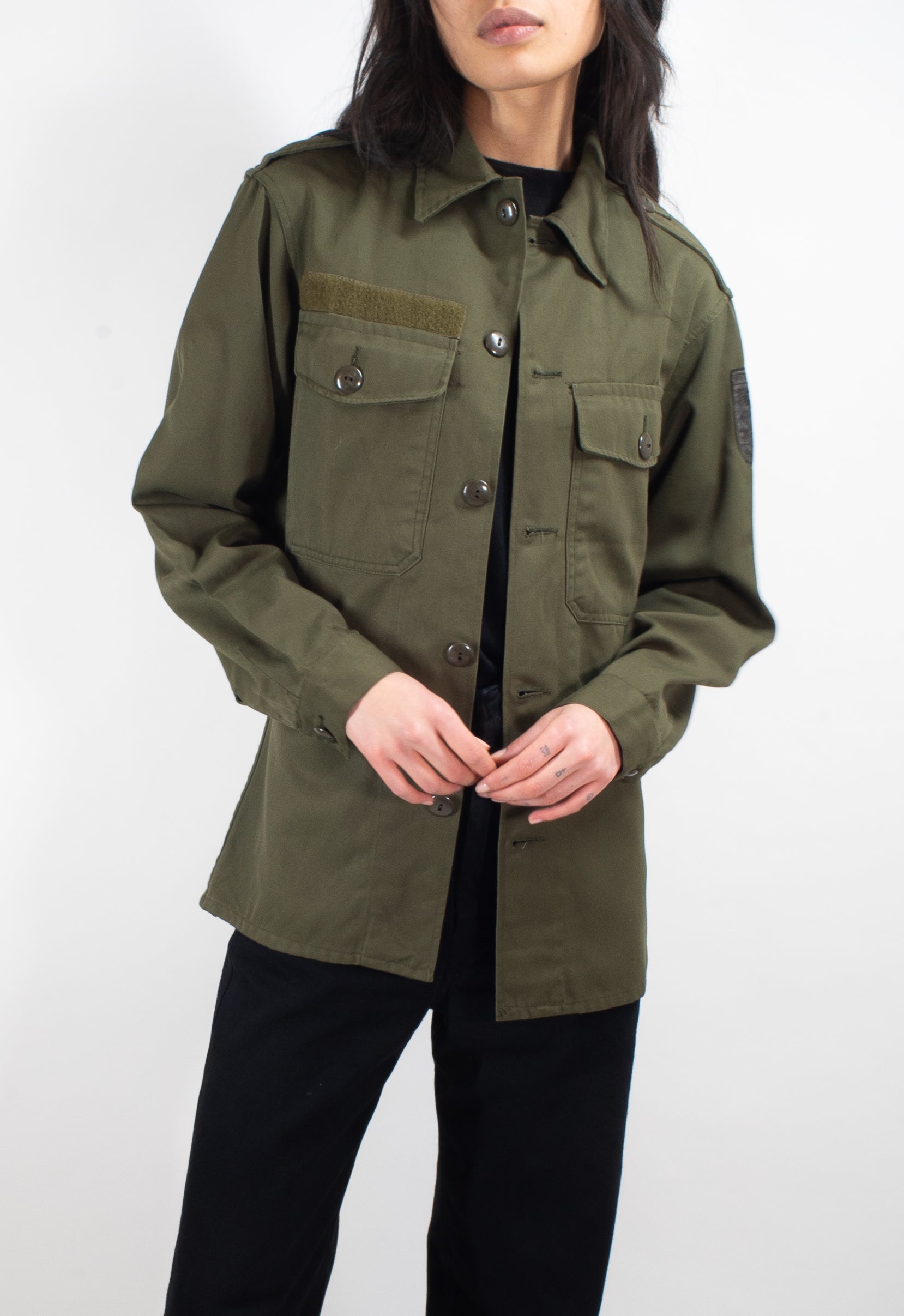 Front-facing view of a woman wearing the vintage Austrian olive army shirt, illustrating the versatile and unisex design.