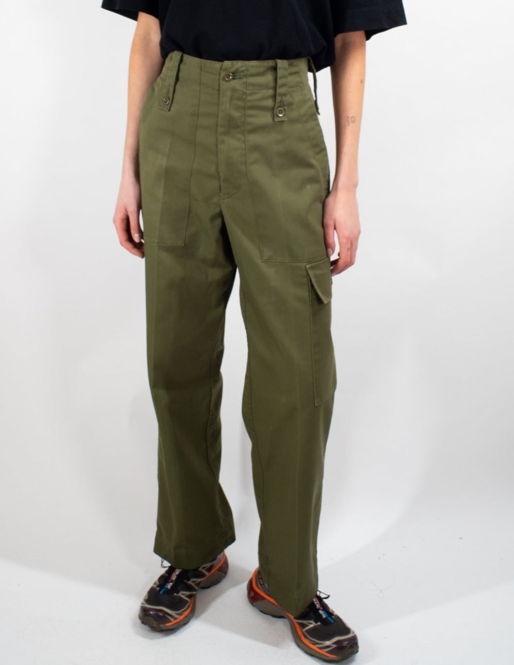 Full-length shot of British Army lightweight olive trousers worn with a black shirt, featuring side cargo pocket detail.