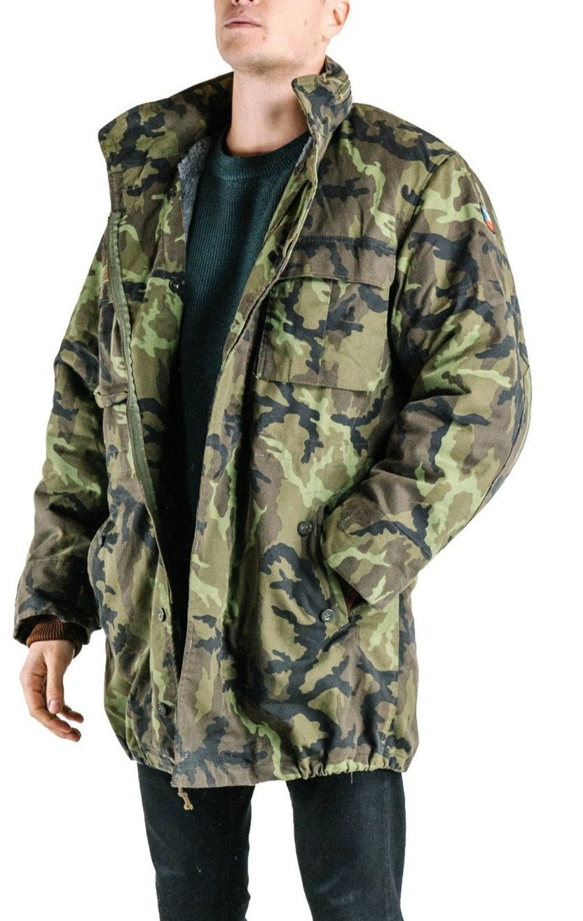 Side profile of the Czech Army M95 parka, highlighting the functional waist hand-warmer pockets and rugged camouflage construction.