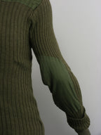 Detailed side view of the olive green military woolly pully, focusing on the reinforced polycotton elbow patch designed for field durability.