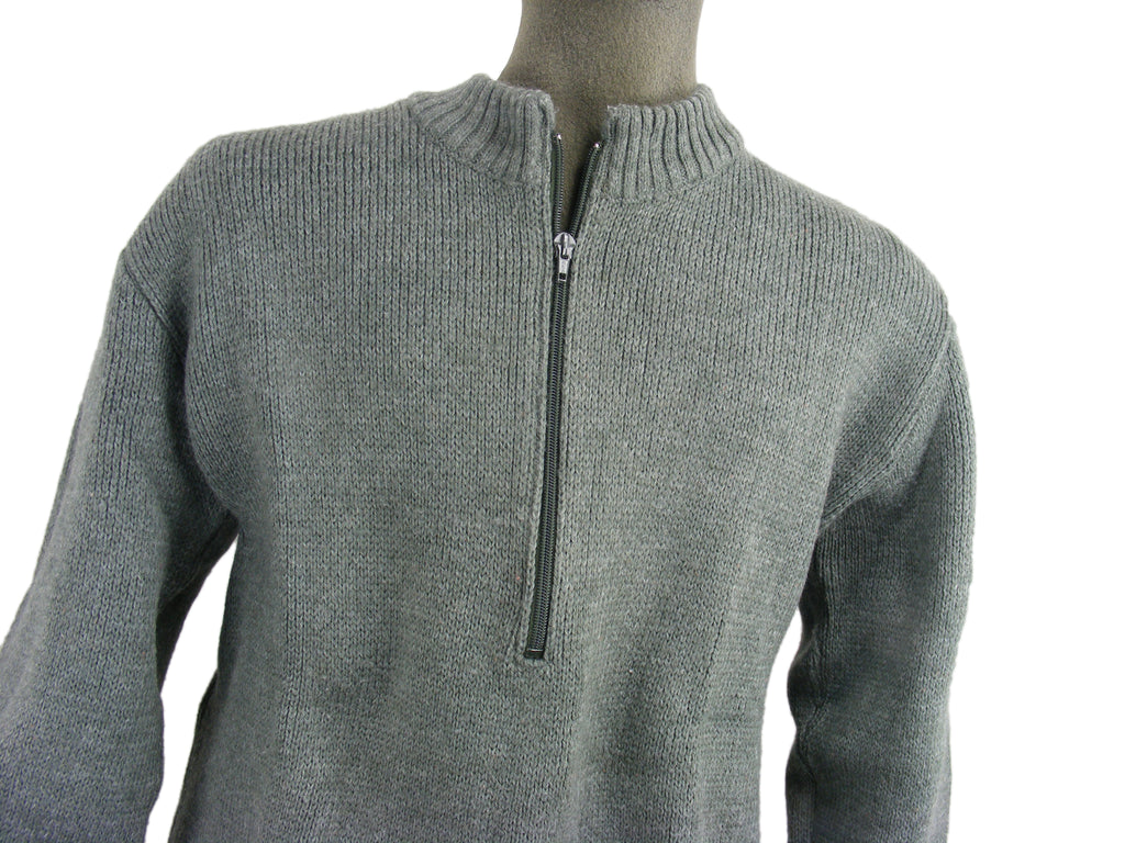Close-up of a grey Swiss military-style wool sweater on a mannequin, highlighting the heavy knit and central zip-neck feature.