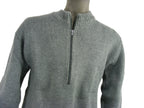 Close-up of a grey Swiss military-style wool sweater on a mannequin, highlighting the heavy knit and central zip-neck feature.