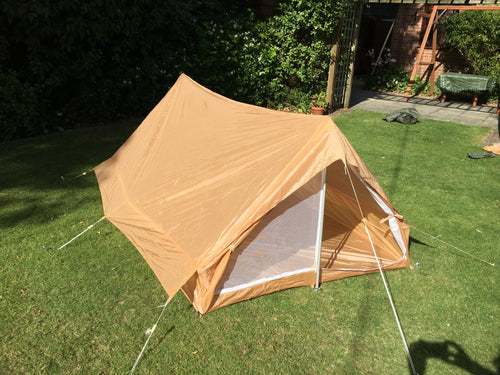 French Military nylon two-man tent in desert coyote color, set up on grass.