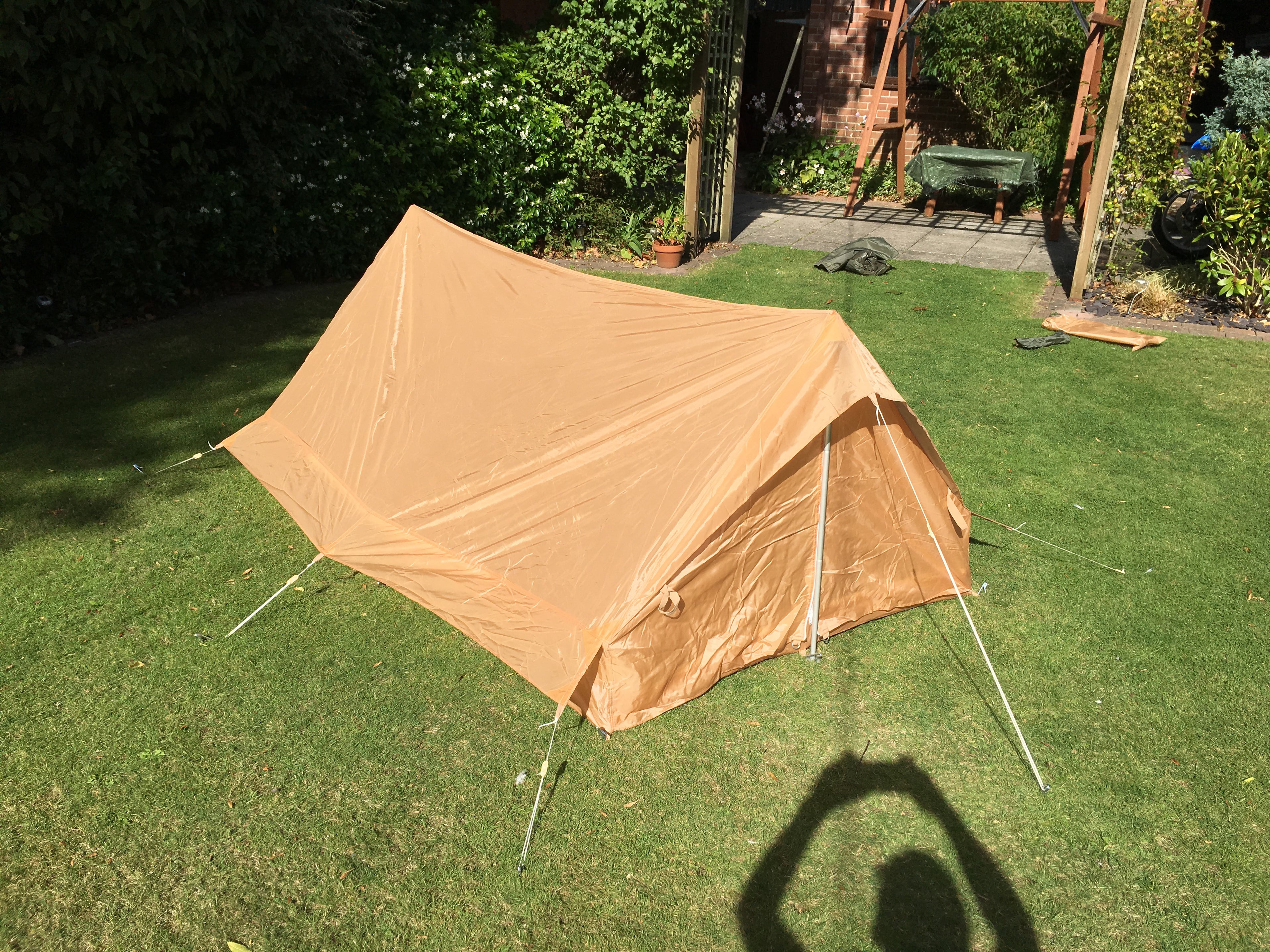 High angle view of the assembled coyote desert tent, showing compact A-frame design.