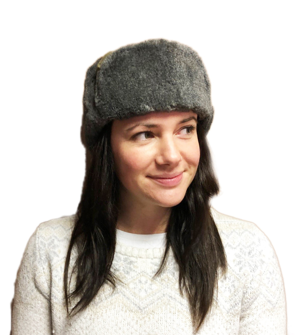 A woman wearing a genuine Czech Army Ushanka winter hat with grey synthetic fur and green fabric crown.