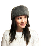 A woman wearing a genuine Czech Army Ushanka winter hat with grey synthetic fur and green fabric crown.