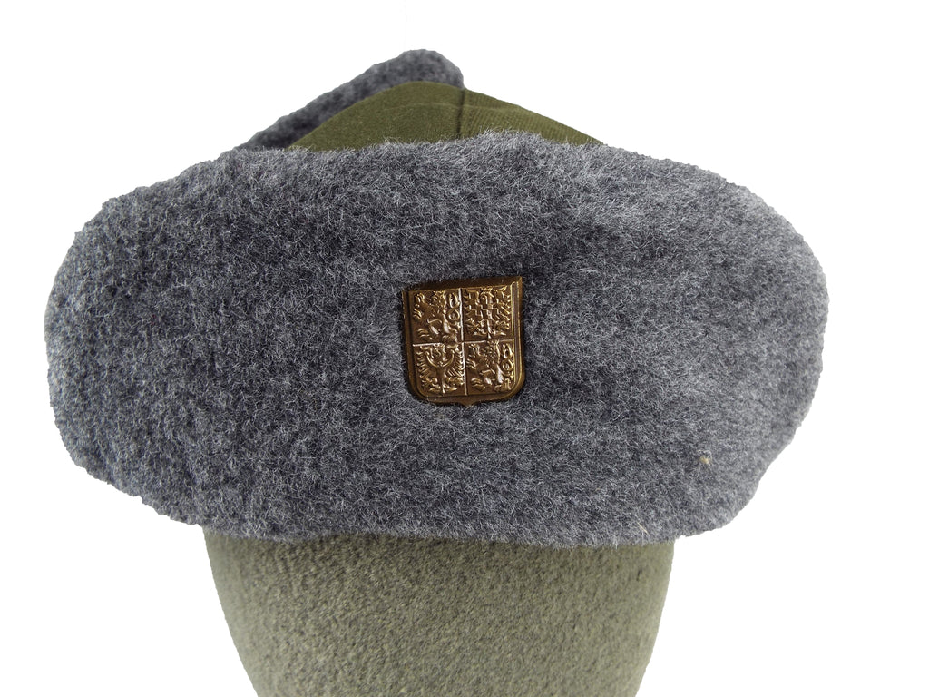 Close-up of the Czech Ushanka front with a detailed look at the metallic coat of arms badge fixed to the synthetic fur.