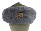 Close-up of the Czech Ushanka front with a detailed look at the metallic coat of arms badge fixed to the synthetic fur.