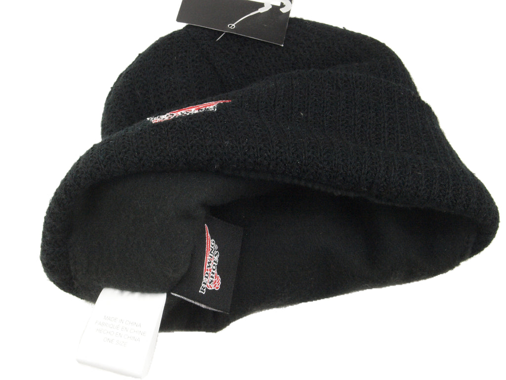 Close-up of the black beanie interior, showing the soft fleece lining, internal Red Wing branding label, and fabric care tag.