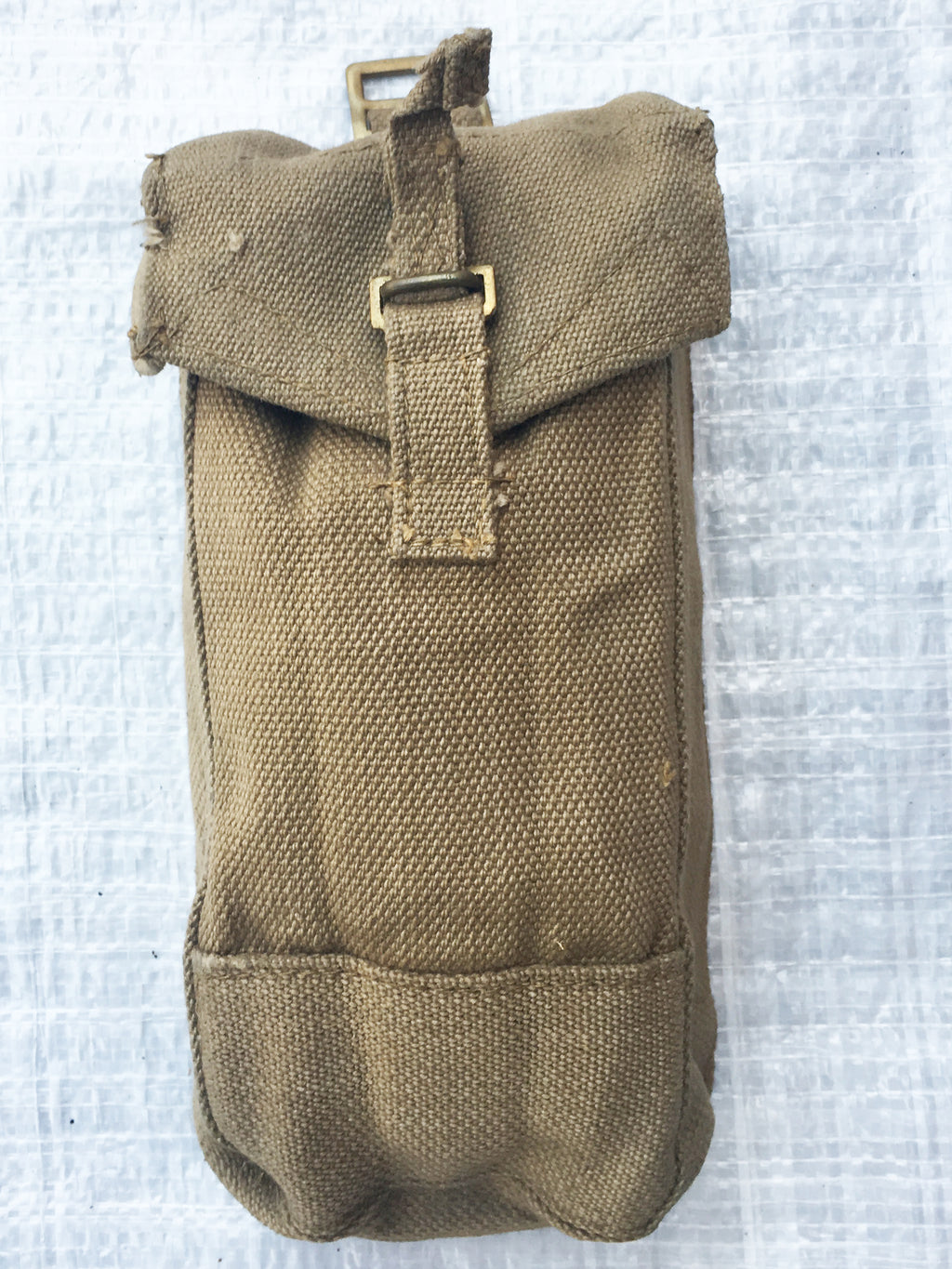 Front view of a durable WW2 era British Army Mark III canvas ammo pouch showing brass hardware and rugged texture.