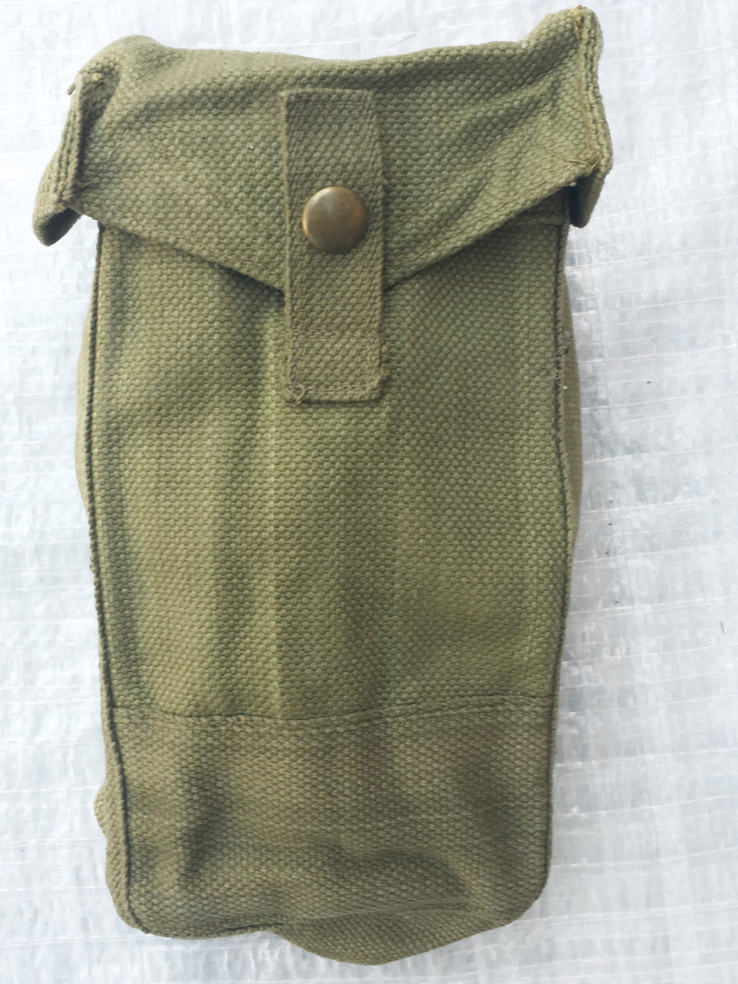 Close-up view of an olive drab WW2 Mark III ammo pouch showcasing the cotton canvas weave and brass press stud detail.