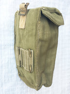 Angled rear view of a green military ammo pouch showing belt attachment hooks and reinforced cotton stitching.