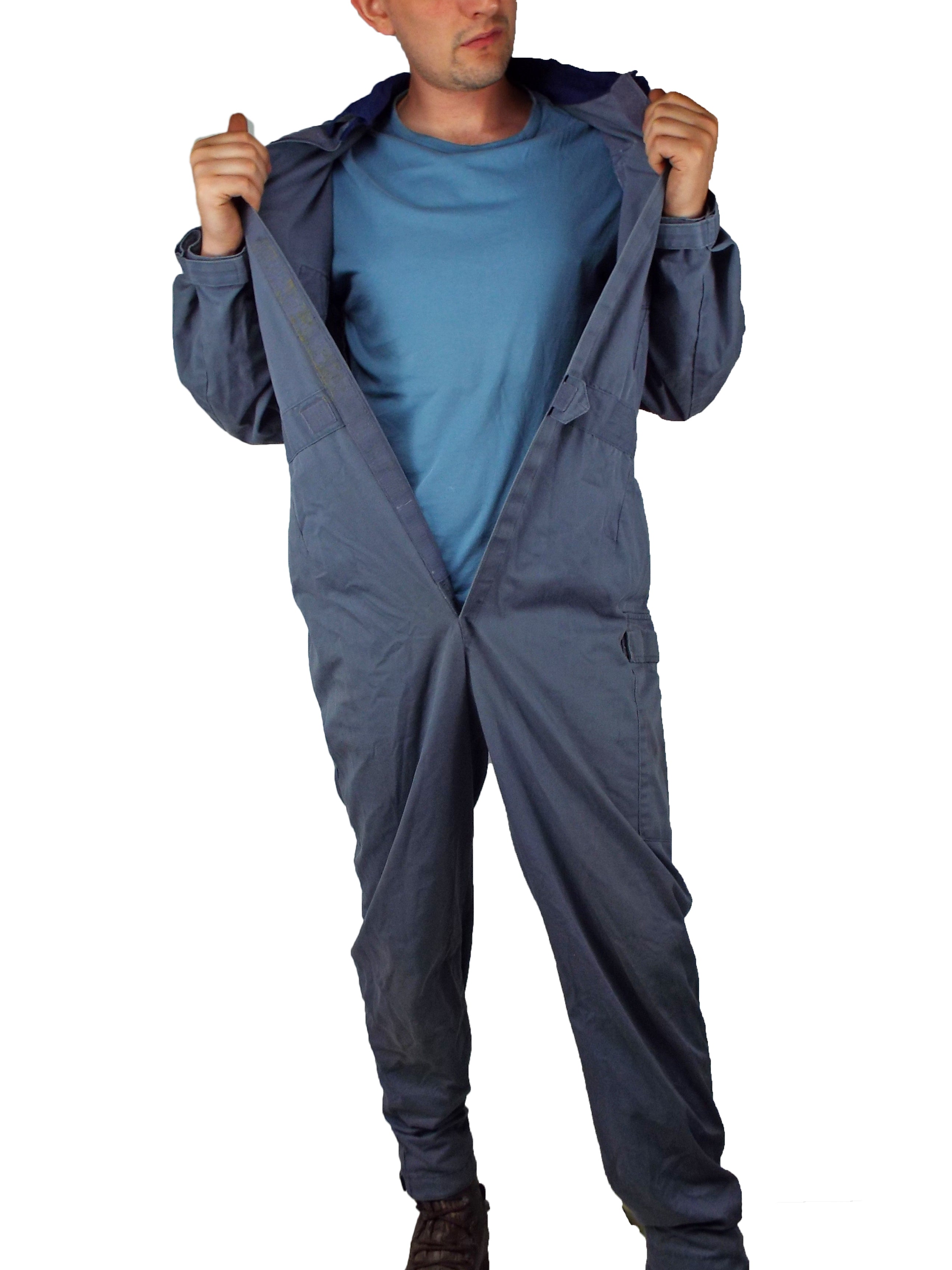 A person demonstrating the easy-access design of the RAF coveralls by unfastening the full-length front closure, revealing the durable build.