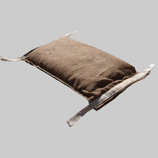 A single water-activated Dam It Up sandless flood bag made of textured jute with beige cotton handling tabs on each corner.