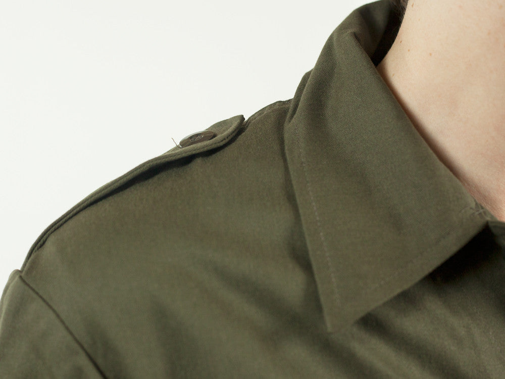 Close-up of the reinforced shoulder epaulettes on the Dutch Army mechanic coveralls, showing durable olive drab stitching.
