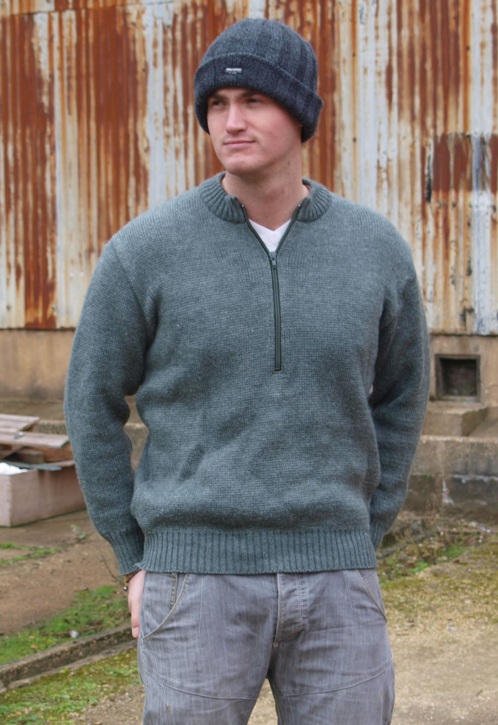 Young man in a grey Swiss Army wool pullover with zip neck detail, wearing a matching grey beanie hat outdoors.