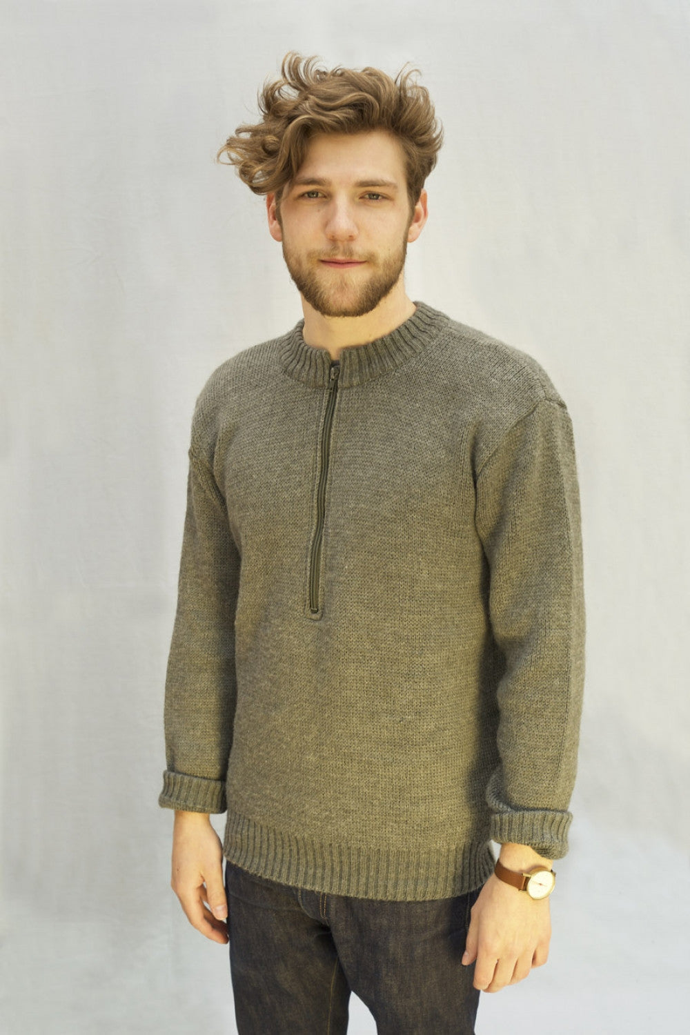 A model wearing a grey Swiss Army wool sweater with a zip-neck design and thick ribbed cuffs.